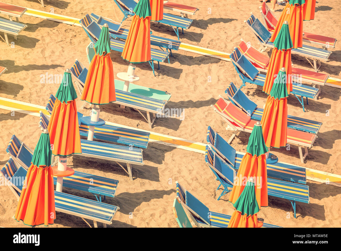 Des chaises longues et des parasols colorés sur une plage vue d'en haut, processus vintage Banque D'Images