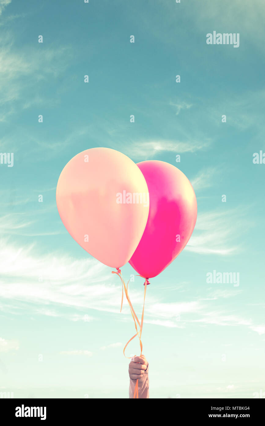 Main d'un enfant tenant des ballons, le fond de ciel, processus vintage Banque D'Images