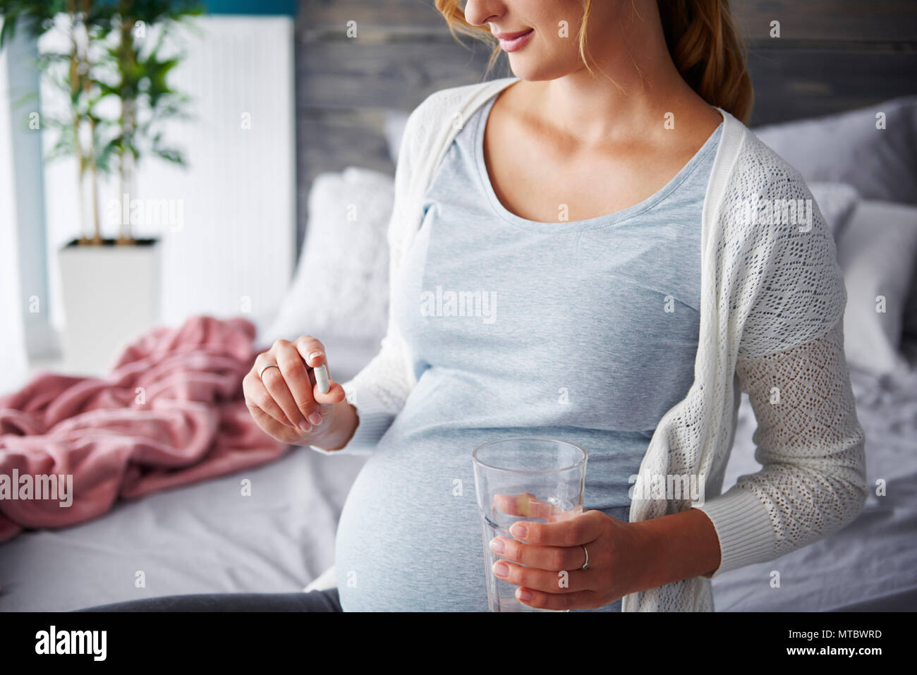 Jeune femme enceinte en tenant capsule Banque D'Images