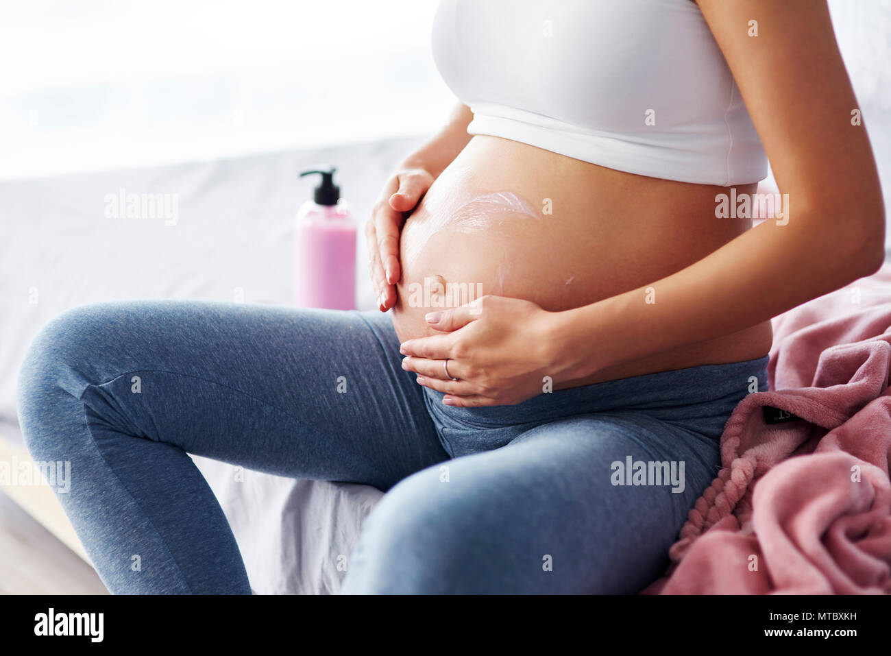 Close up de femmes enceintes applying moisturizer Banque D'Images