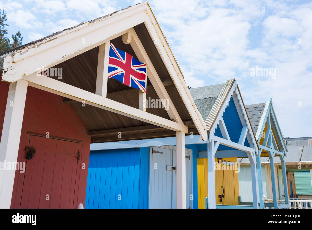 Cabines de plage colorées abris avec la British Union Jack flag peint à la main sur elle Banque D'Images