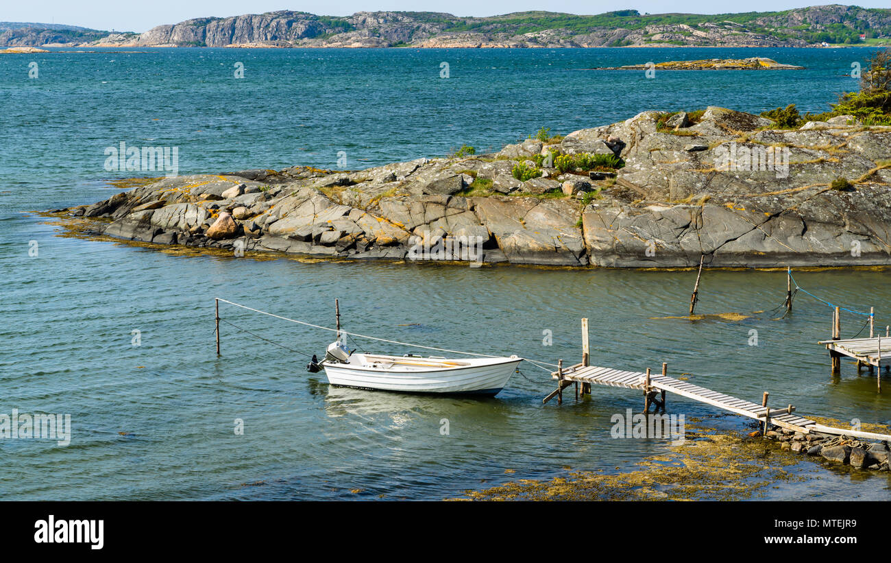 Petit bateau amarré par une jetée dans l'archipel rocheux sur une journée ensoleillée. Tjuvkil Emplacement extérieur Kungalv, Suède. Banque D'Images