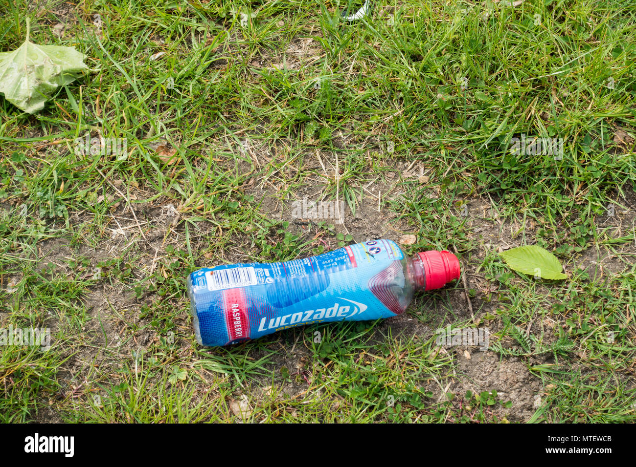 Une bouteille de Lucozade en plastique qui a été jeté sur l'herbe, Dorset, Angleterre, Royaume-Uni Banque D'Images