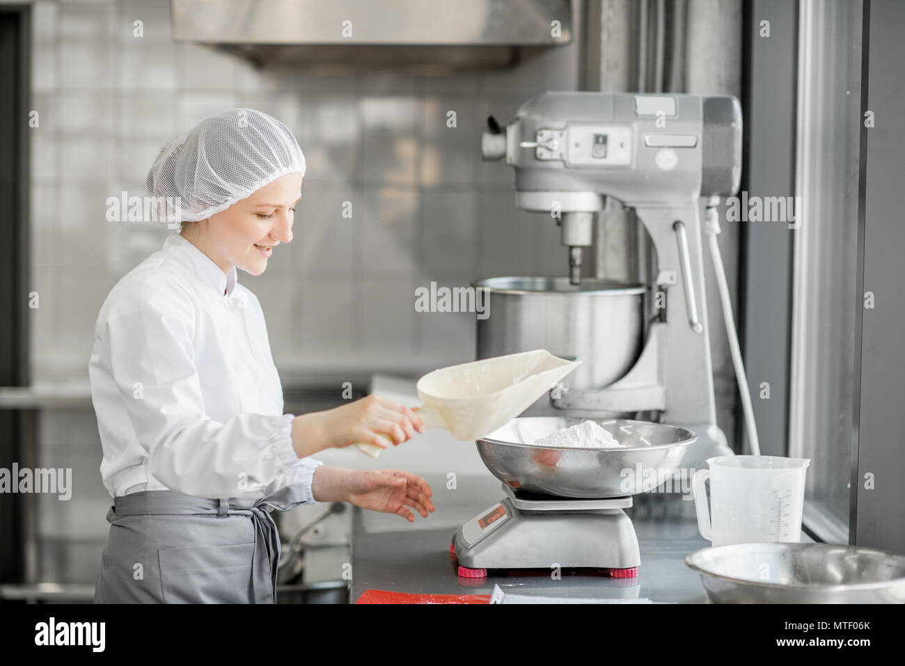 Confiseur femme en uniforme d'un poids ingrédients pour pâtisserie travaillant à la fabrication de boulangerie Banque D'Images