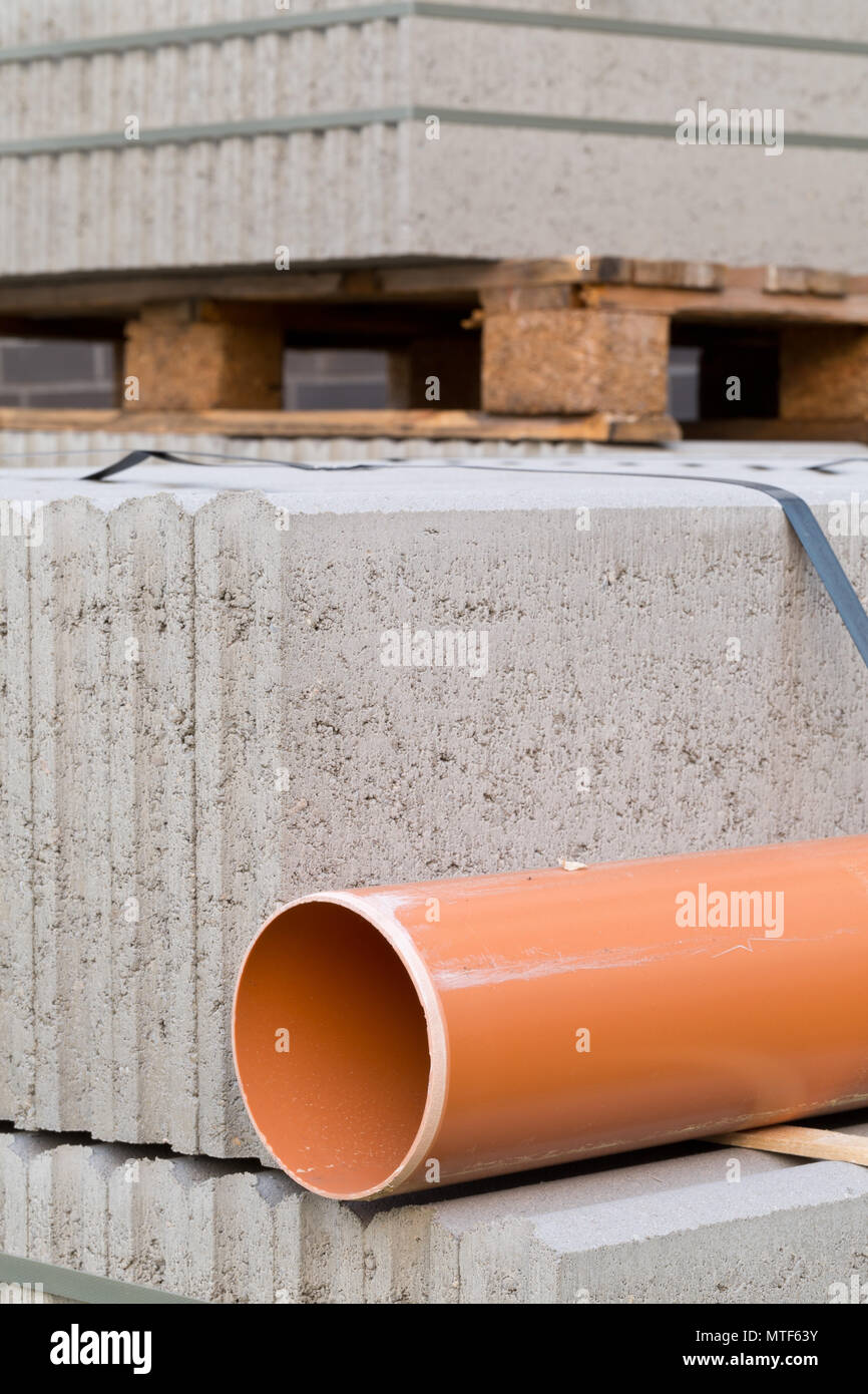 Les blocs de béton et de plastique pvc tuyau d'égout sur la palette à l'immeuble construction site Banque D'Images