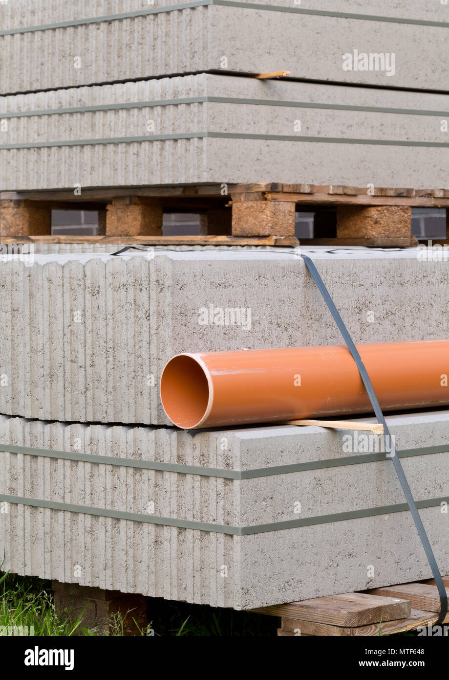 Les blocs de béton et de plastique pvc tuyau d'égout sur la palette à l'immeuble construction site Banque D'Images