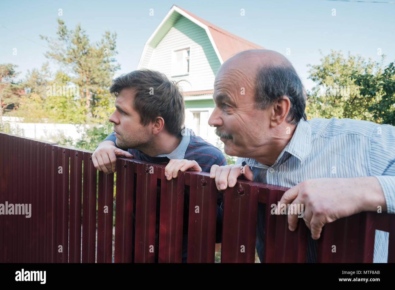 Deux hommes de race blanche attentivement par-dessus la clôture. Banque D'Images