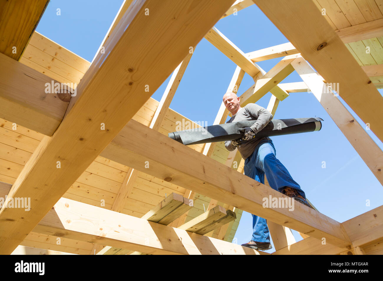 Builder au travail avec un toit en bois de construction. Banque D'Images
