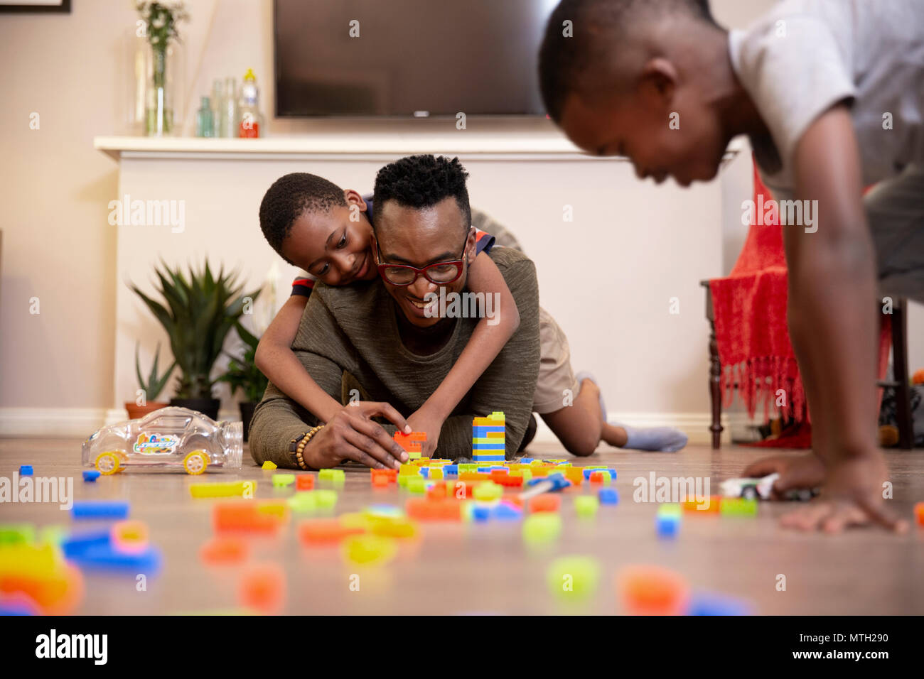 Père et fils jouer avec ses jouets sur le plancher Banque D'Images