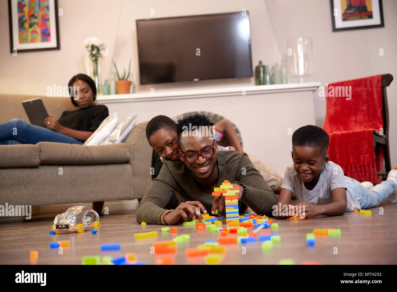 Père et fils jouer avec ses jouets sur le plancher Banque D'Images