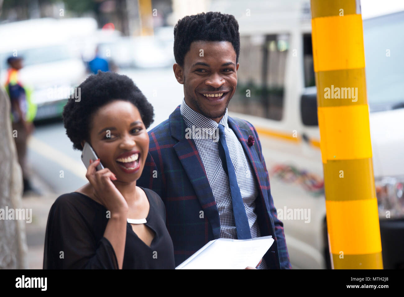 Homme et femme d'affaires en attente au feu de circulation Banque D'Images