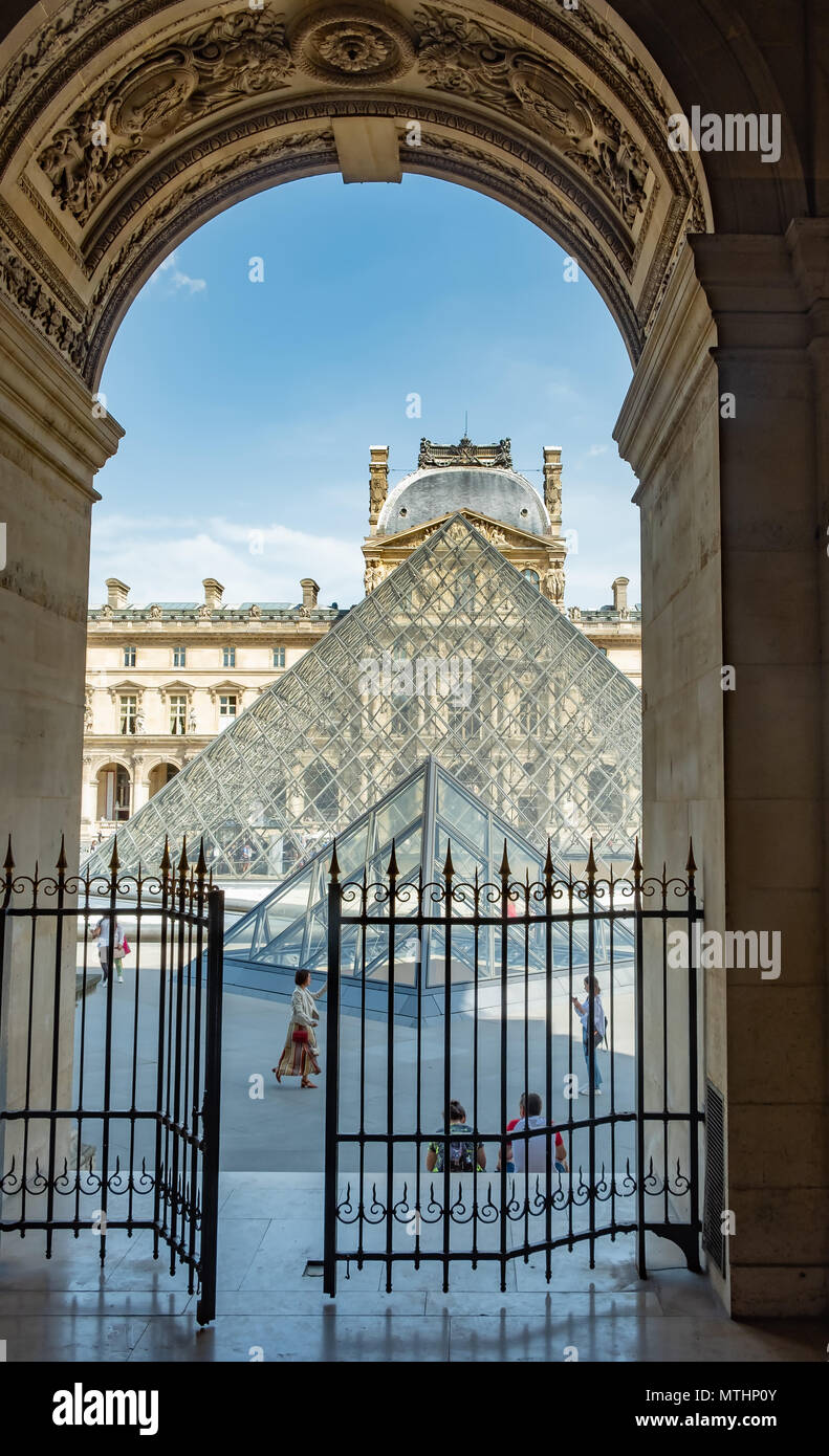 Grâce à une arche vers la Pyramide du Louvre à Paris, France. Une ancienne forteresse et palais, le Louvre est le plus grand musée d'art en t Banque D'Images