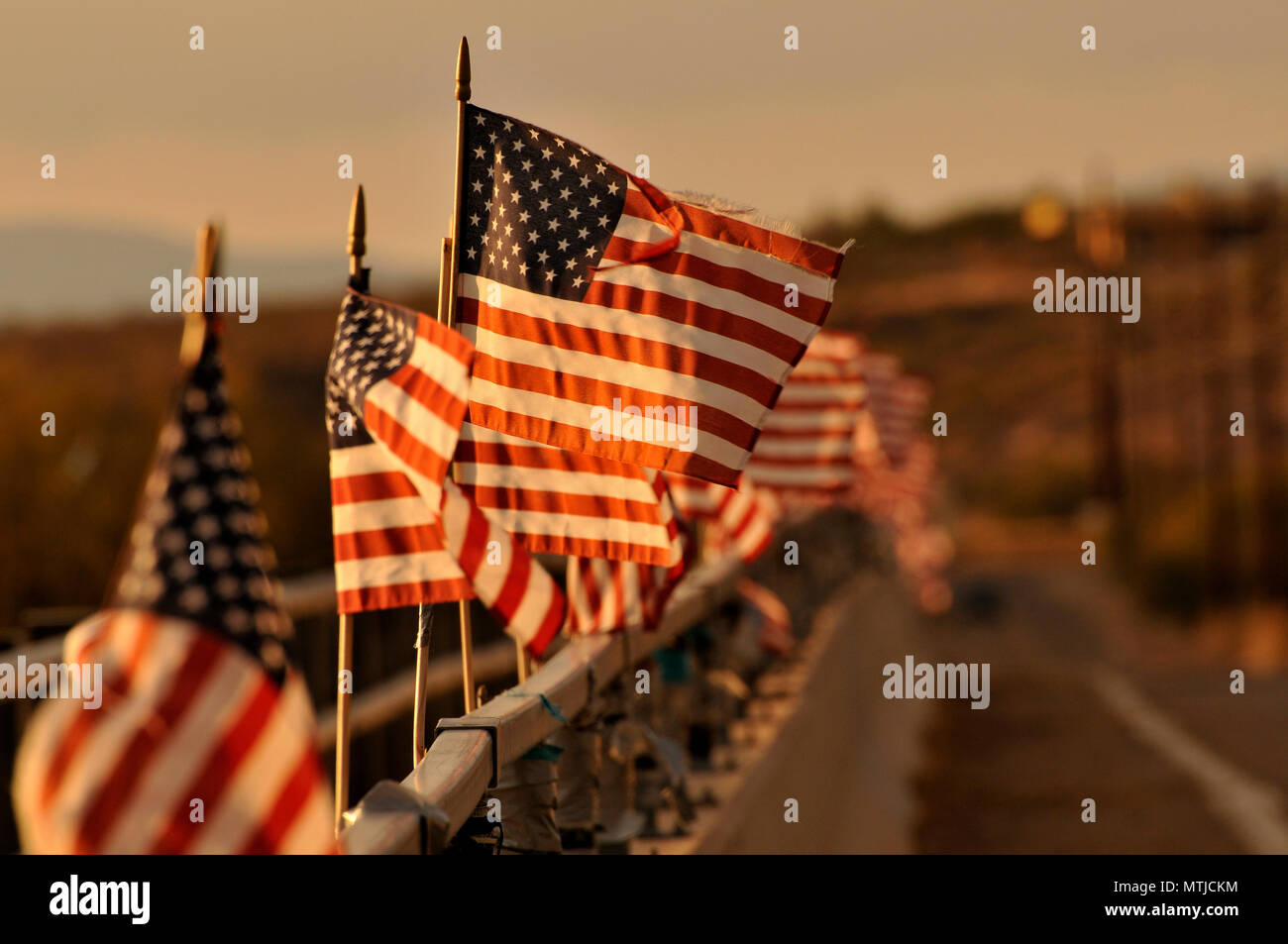 Drapeaux américain attaché à un pont au-dessus de la rivière de Santa Cruz dans le vent souffler à Green Valley, Arizona, USA. Banque D'Images