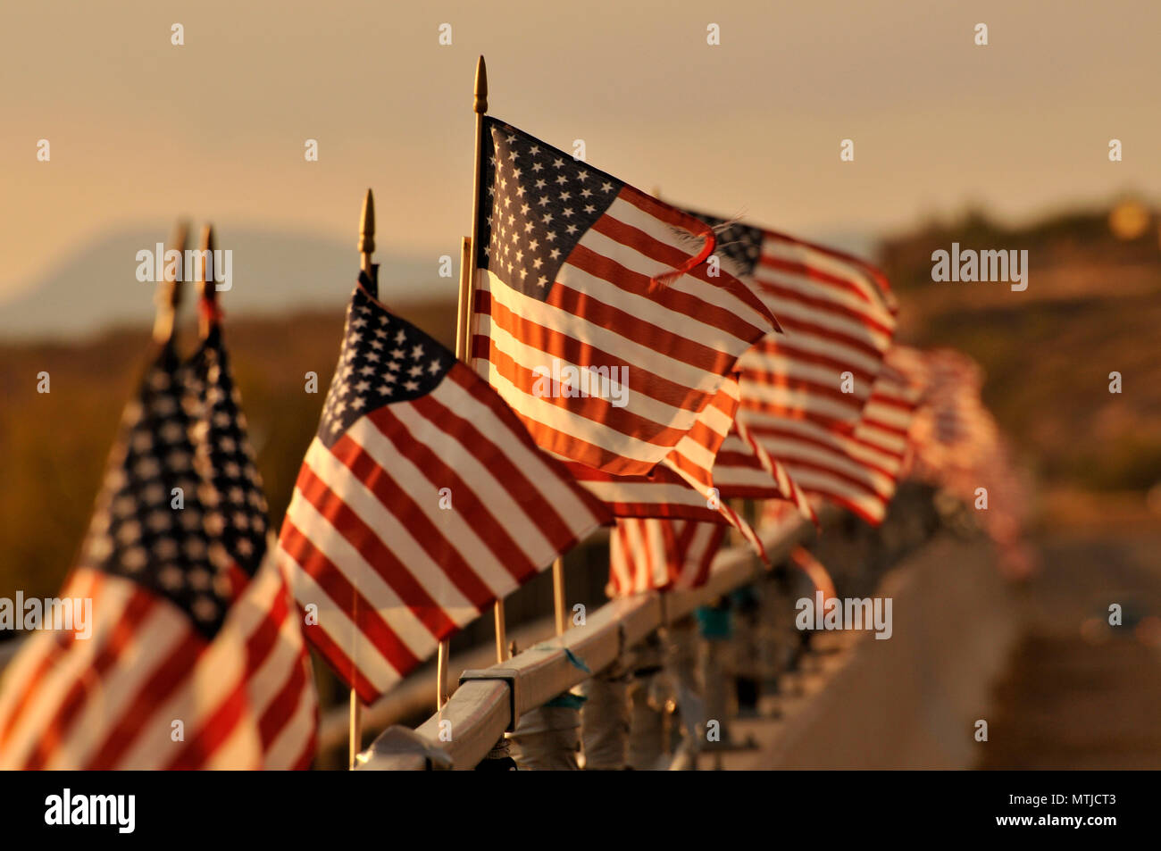 Drapeaux américain attaché à un pont au-dessus de la rivière de Santa Cruz dans le vent souffler à Green Valley, Arizona, USA. Banque D'Images