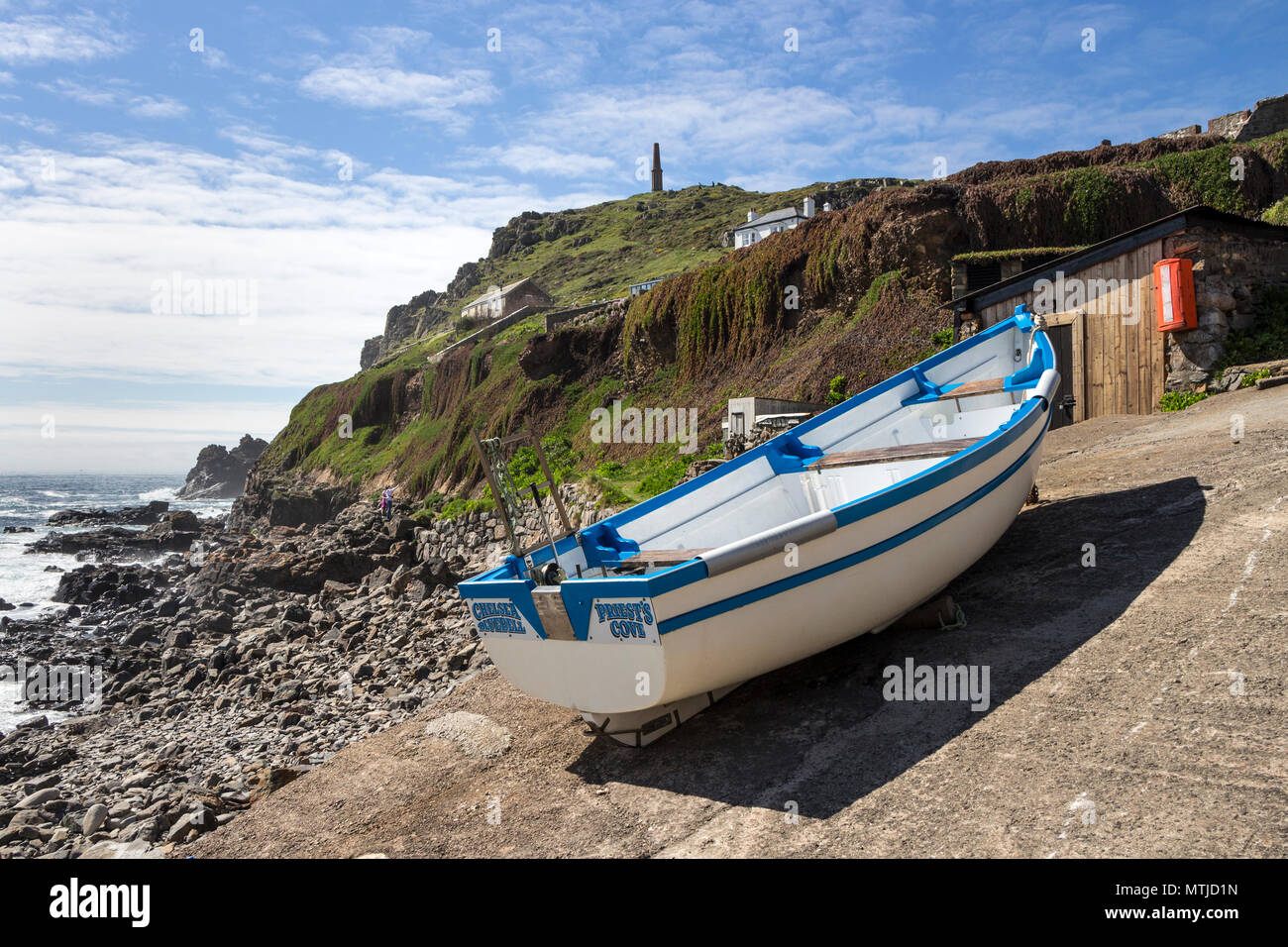 Bateau de pêche sur la cale de halage de Priest's Cove, avec la cheminée de 1864 Cape Cornwall Mine dans l'arrière-plan, Cornwall, UK Banque D'Images