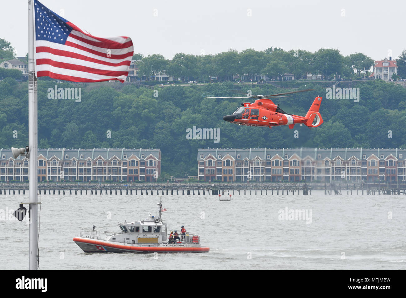 Une garde robe MH-65 Dolphin plane au-dessus de la Garde côtière canadienne une réponse Boat-Medium de 45 pieds, tout en démontrant une évolution de recherche et de sauvetage au large du quai 86 de la Fleet Week à New York, le 28 mai 2018. La Semaine de la flotte est une occasion unique pour les citoyens de New York et la région des trois états pour répondre marins, marines et gardes côte, ainsi que témoin de première main les dernières capacités des services maritimes d'aujourd'hui. (U.S. Photo de la Garde côtière canadienne par le maître de 3e classe Steve Strohmaier) Banque D'Images