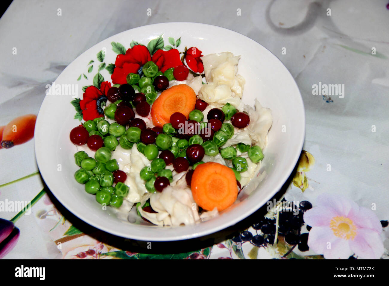 Salade végétarienne est sur le plat rond orné de motif de rose rouge Banque D'Images