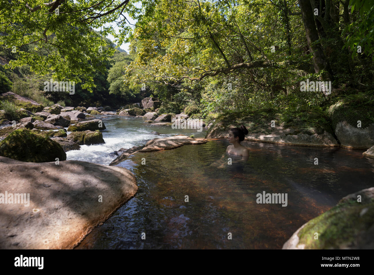 Woman bathing in outdoor onsen / Hot Spring à Myoken Ishikaraso, Kirishima, Kyushu, Japon Banque D'Images