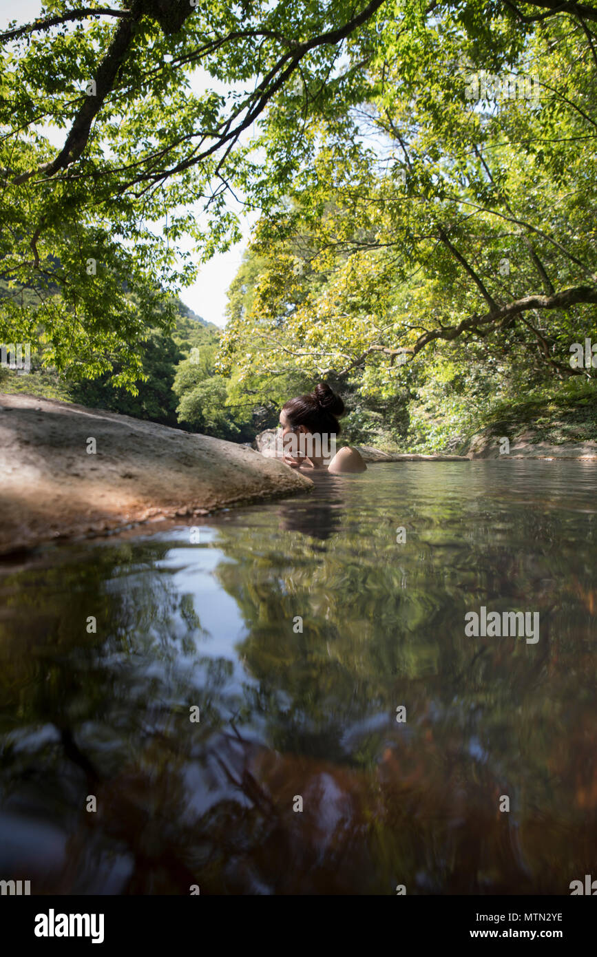 Woman bathing in outdoor onsen / Hot Spring à Myoken Ishikaraso, Kirishima, Kyushu, Japon Banque D'Images