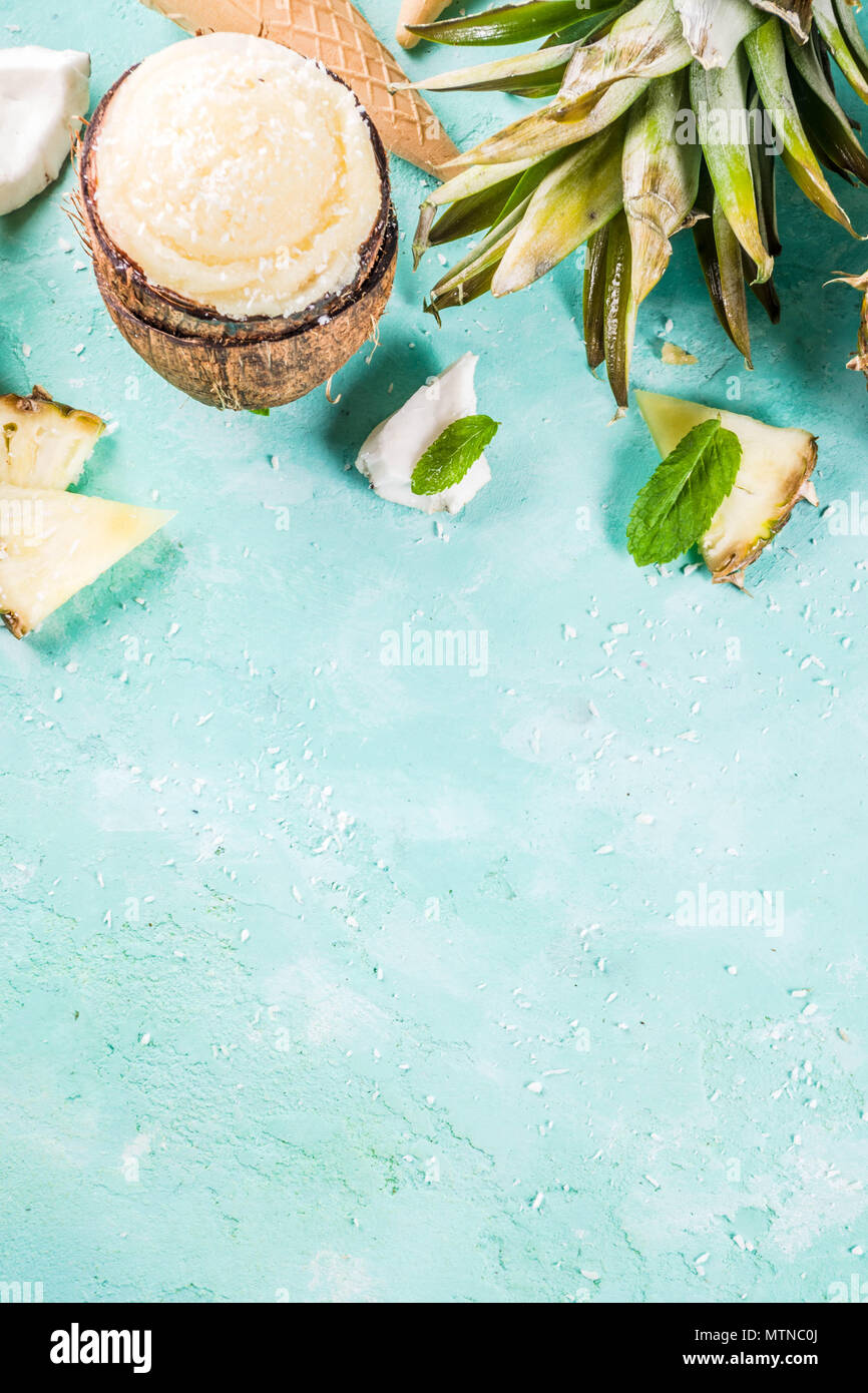 Maison de vacances d'été, définir diverses glaces sorbets tropicaux, jus congelés dans des ananas, pamplemousse et noix de coco, bleu clair béton backg Banque D'Images