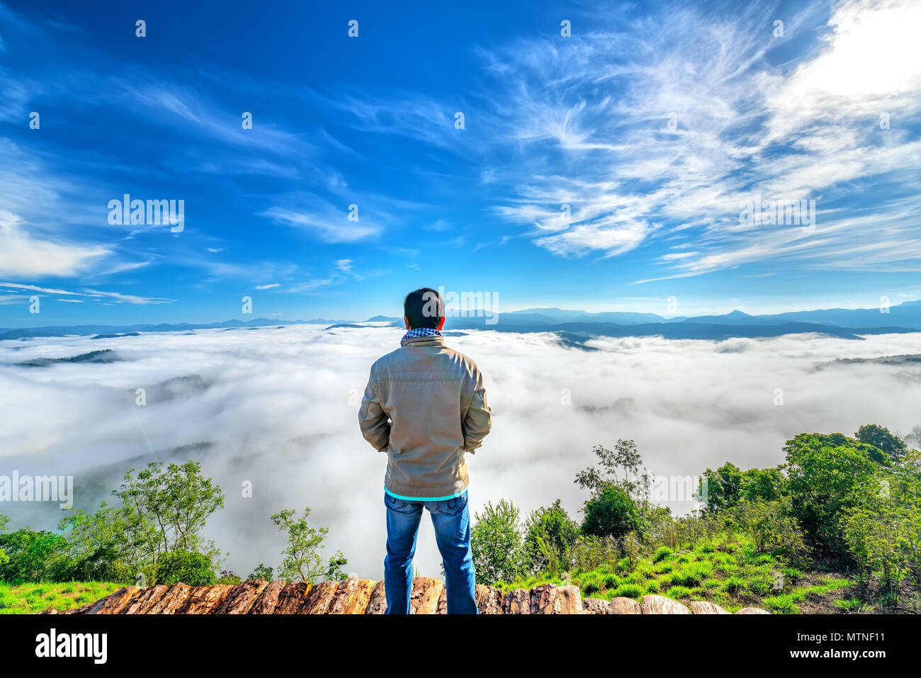 Silhouette jeune homme debout sur une haute colline rural pittoresque ville d'origine, dans la vallée de montagnes enveloppées de brouillard matin dessinent à l'endroit pittoresque vallonné Banque D'Images