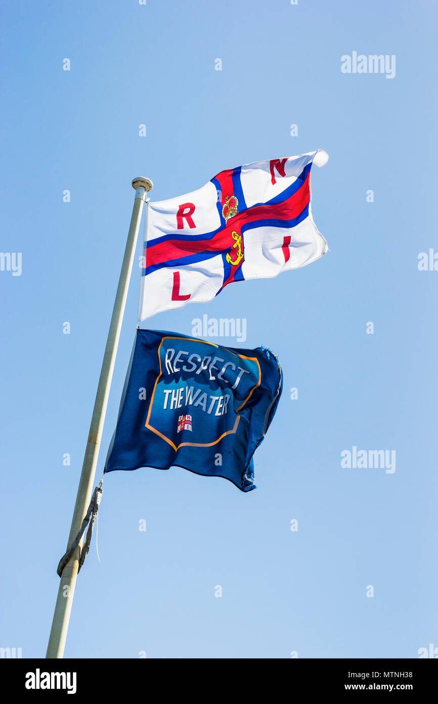 L'eau et le respect de la RNLI flags against a blue sky with copy space Banque D'Images