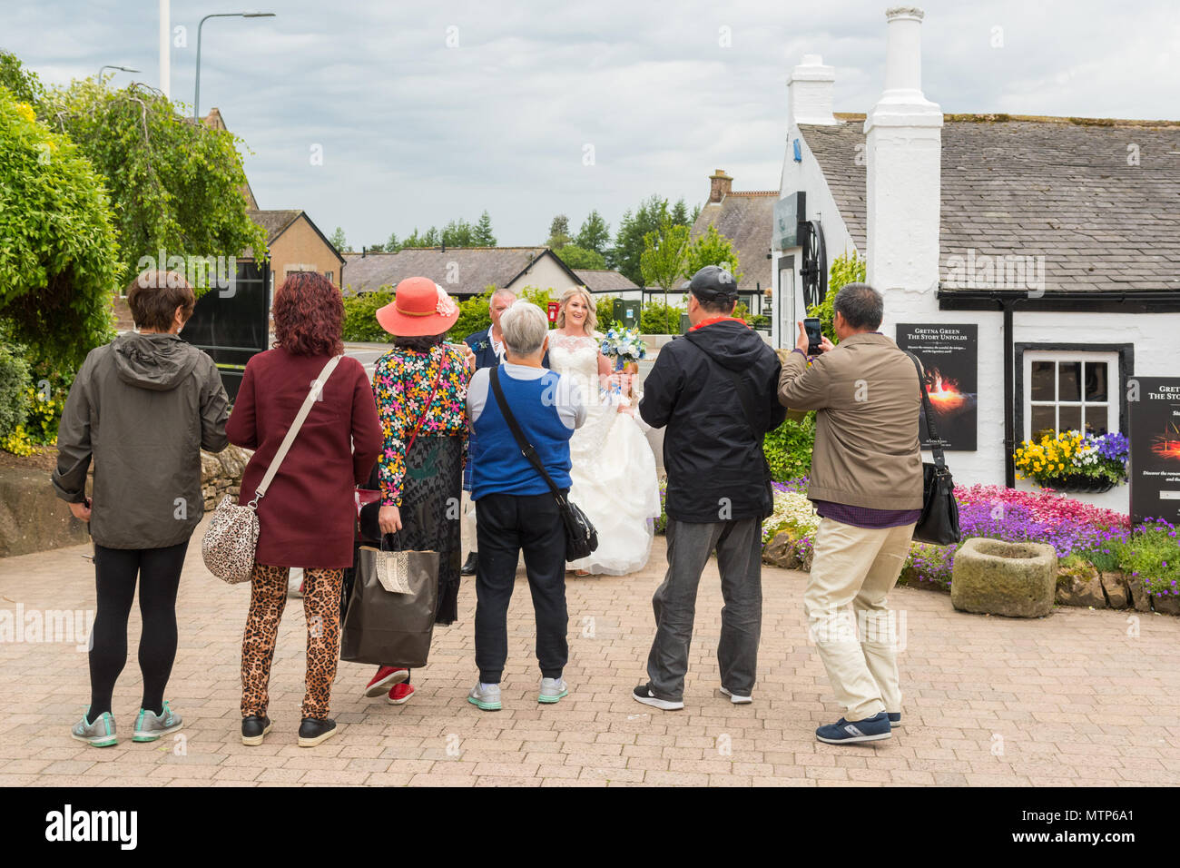 Les touristes asiatiques de prendre des photographies d'une épouse arrivant pour son mariage à Gretna Green, Ecosse, Royaume-Uni Banque D'Images