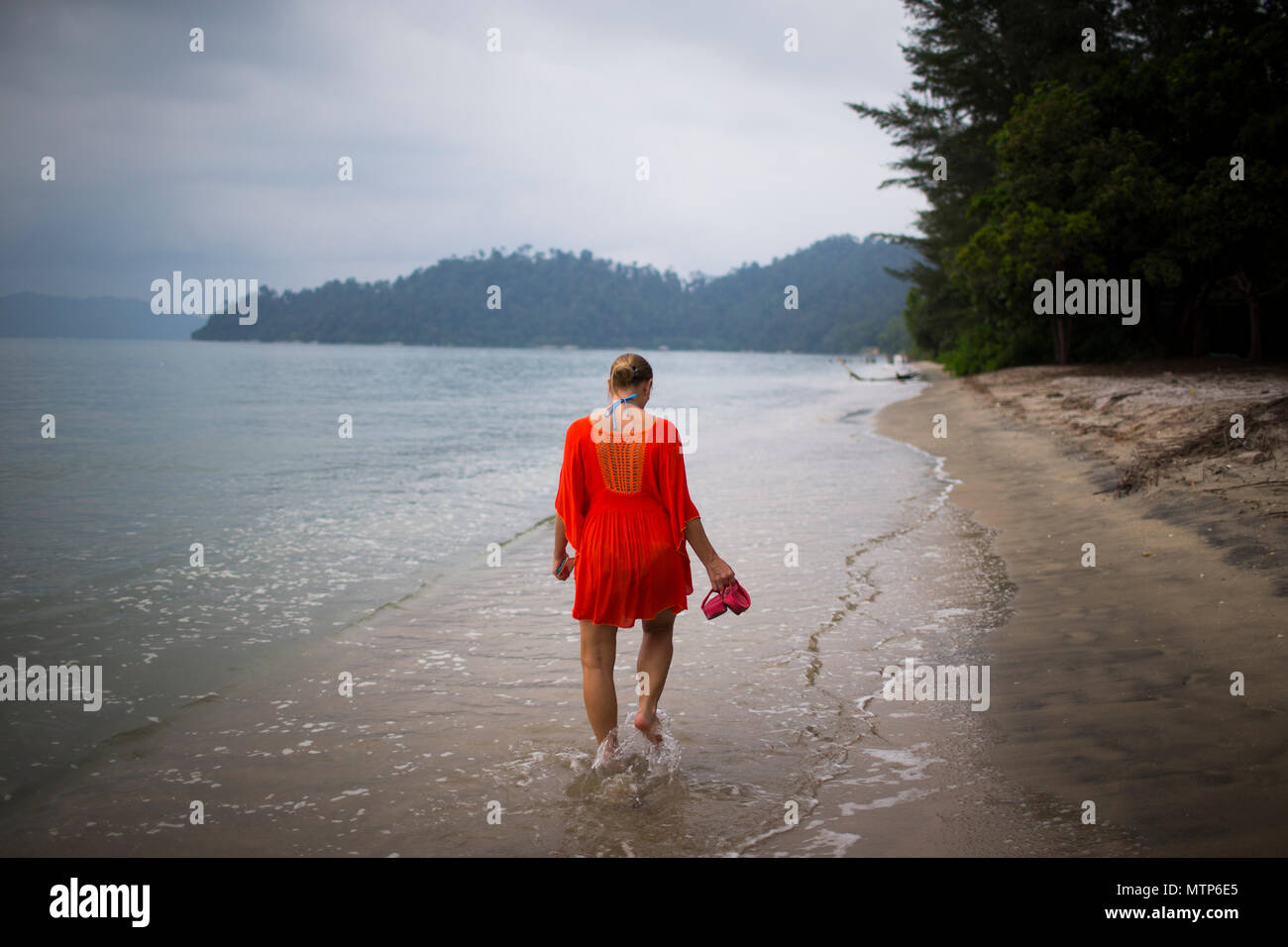 Une femme blonde déambule le long de la plage au Damai Laut en Malaisie. Banque D'Images