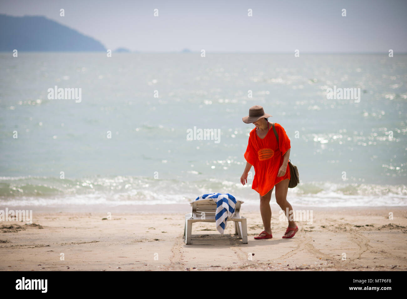Une femme blonde déambule le long de la plage au Damai Laut en Malaisie. Banque D'Images