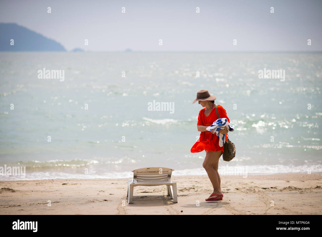 Une femme blonde déambule le long de la plage au Damai Laut en Malaisie. Banque D'Images