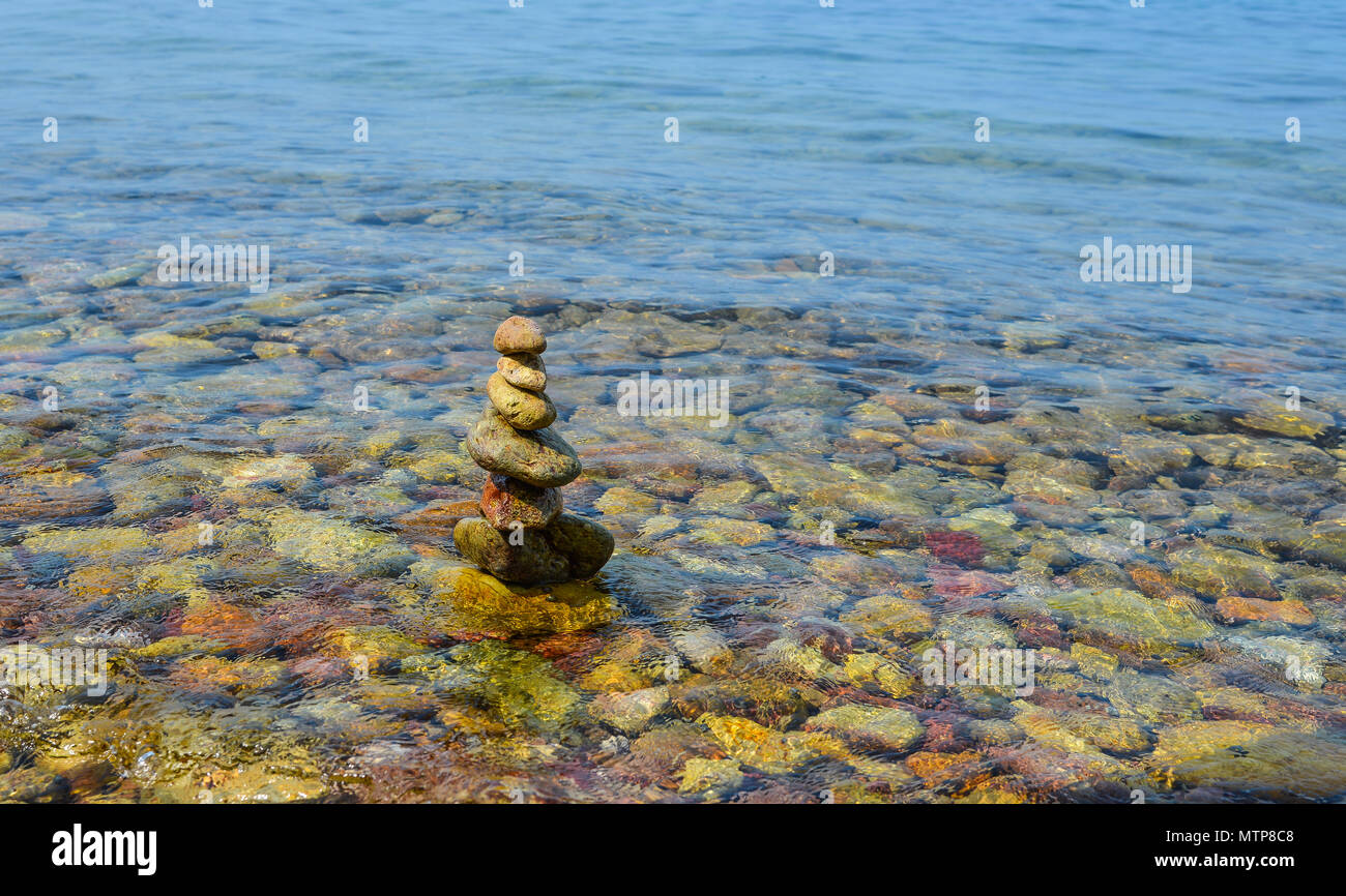 Pierres et mer roches multicolores sur la plage au soleil. Banque D'Images