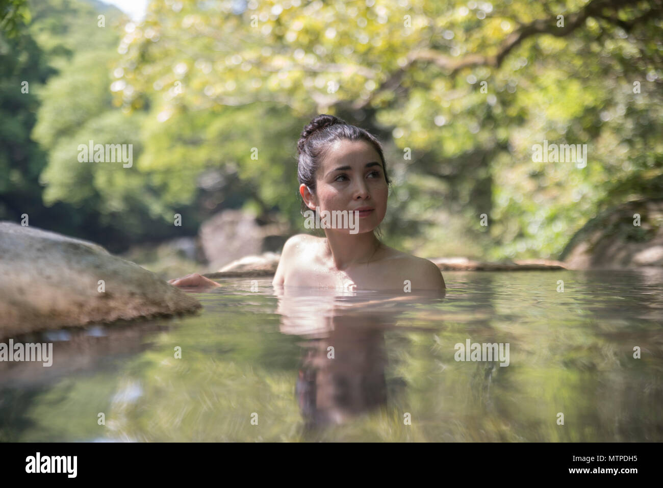 Woman bathing in outdoor onsen / Hot Spring à Myoken Ishikaraso, Kirishima, Kyushu, Japon Banque D'Images