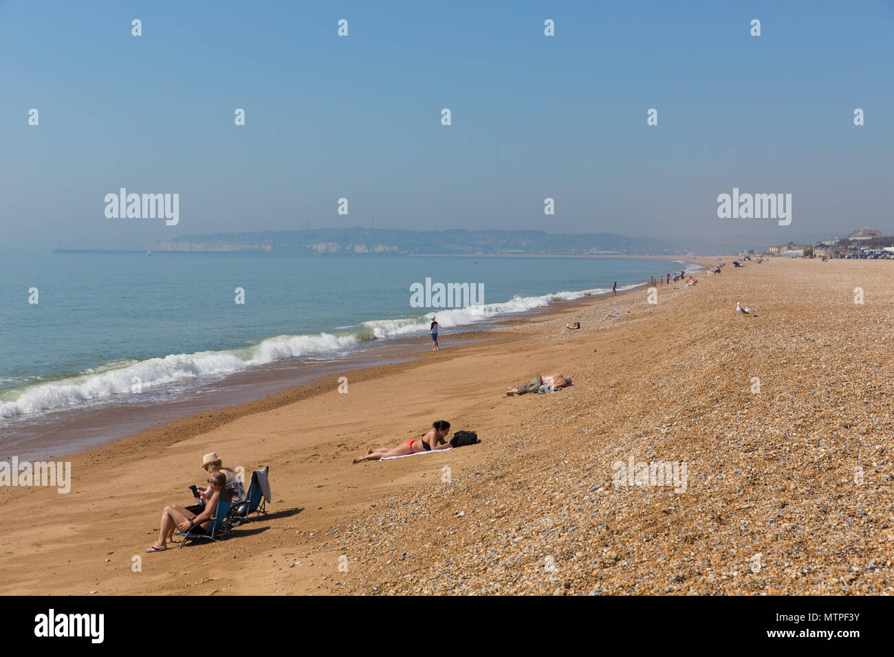 La plage de Seaford avec les gens de transats, bains de soleil et les vagues East Sussex UK Banque D'Images