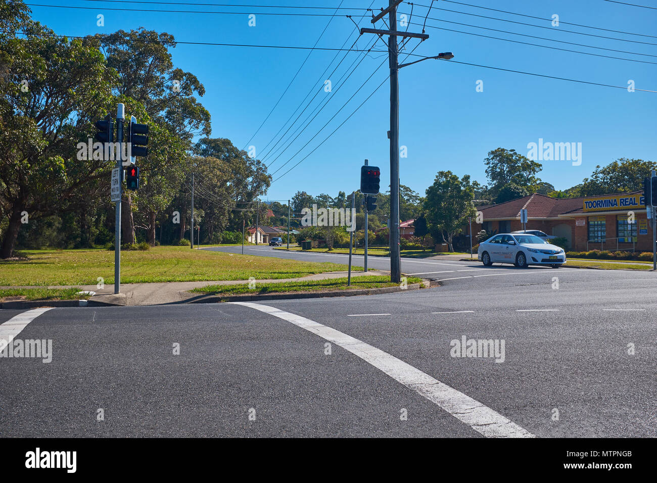 Un franchissement routier au Toormina avec feux de circulation rouge et montrant un taxi à la jonction, New South Wales, Australie Banque D'Images