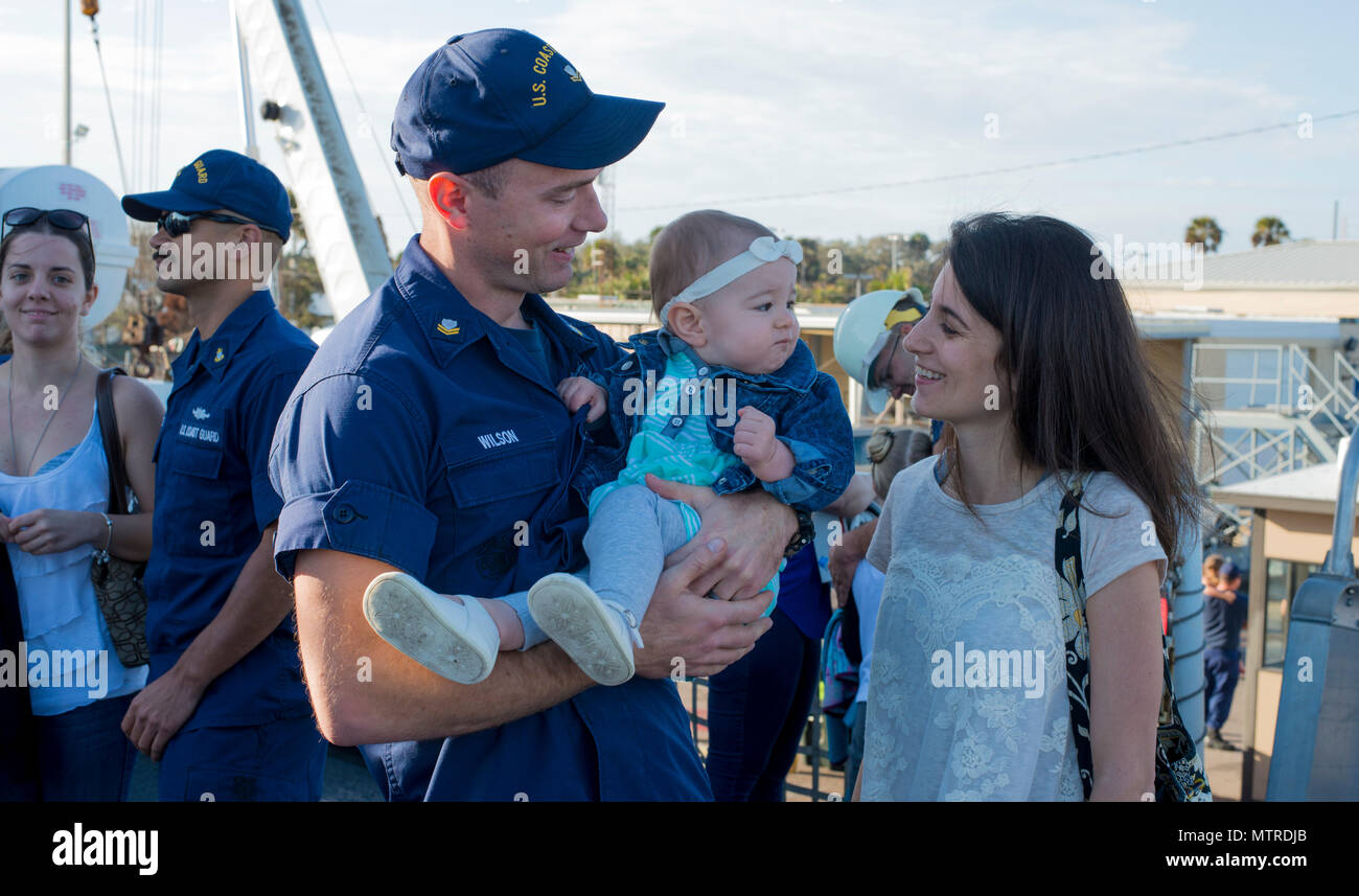 Un garde-côte de valeureux équipage rencontre avec sa femme et son enfant après son retour du navire au port d'attache à la Station Navale de Mayport, Florida après 5 semaines d'interdiction migrants patrouille. Au cours de leur déploiement dans le détroit de Floride, le valeureux équipage secourus, soignés et rapatrié 307 émigrés cubains qui tente d'entrer aux États-Unis. U.S. Coast Guard photo de Maître de 2e classe Anthony L. Soto Banque D'Images