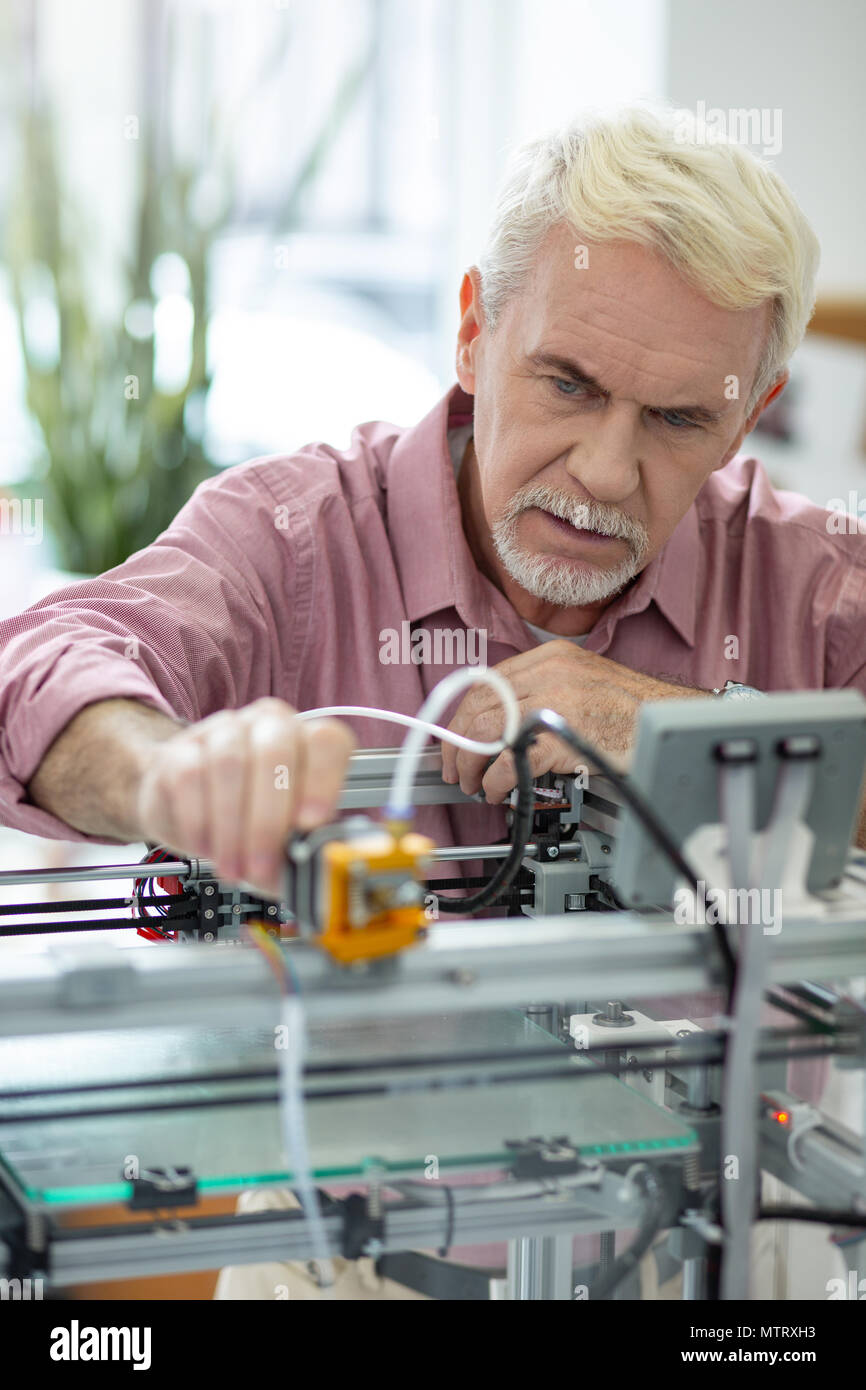 Bel homme âgé de l'extrudeuse de réglage de l'imprimante 3D Banque D'Images