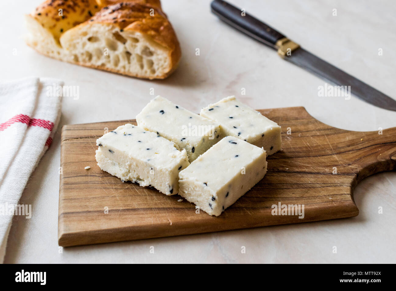 Fromage Feta turc avec Le Cumin Noir (graines de sésame) sur la surface en bois avec couteau. Aliments biologiques traditionnelles. Banque D'Images