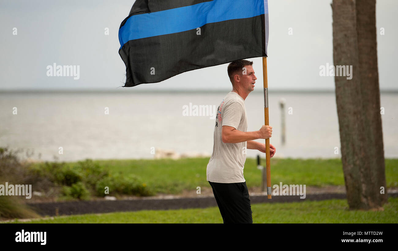 U.S. Air Force Tech. Le Sgt. Jeremy Stull, un chef de vol assigné à la 6e Escadron des Forces de Sécurité, fonctionne avec une fine ligne bleue indicateur après une réception ouverte 24h vigilance fonctionner à la base aérienne MacDill, Floride a célébré la Semaine de la police MacDill avec une variété d'activités pour souligner les contributions et les sacrifices des membres des forces de l'ordre dans le monde. (U.S. Air Force photo par un membre de la 1re classe Caleb Nunez) Banque D'Images