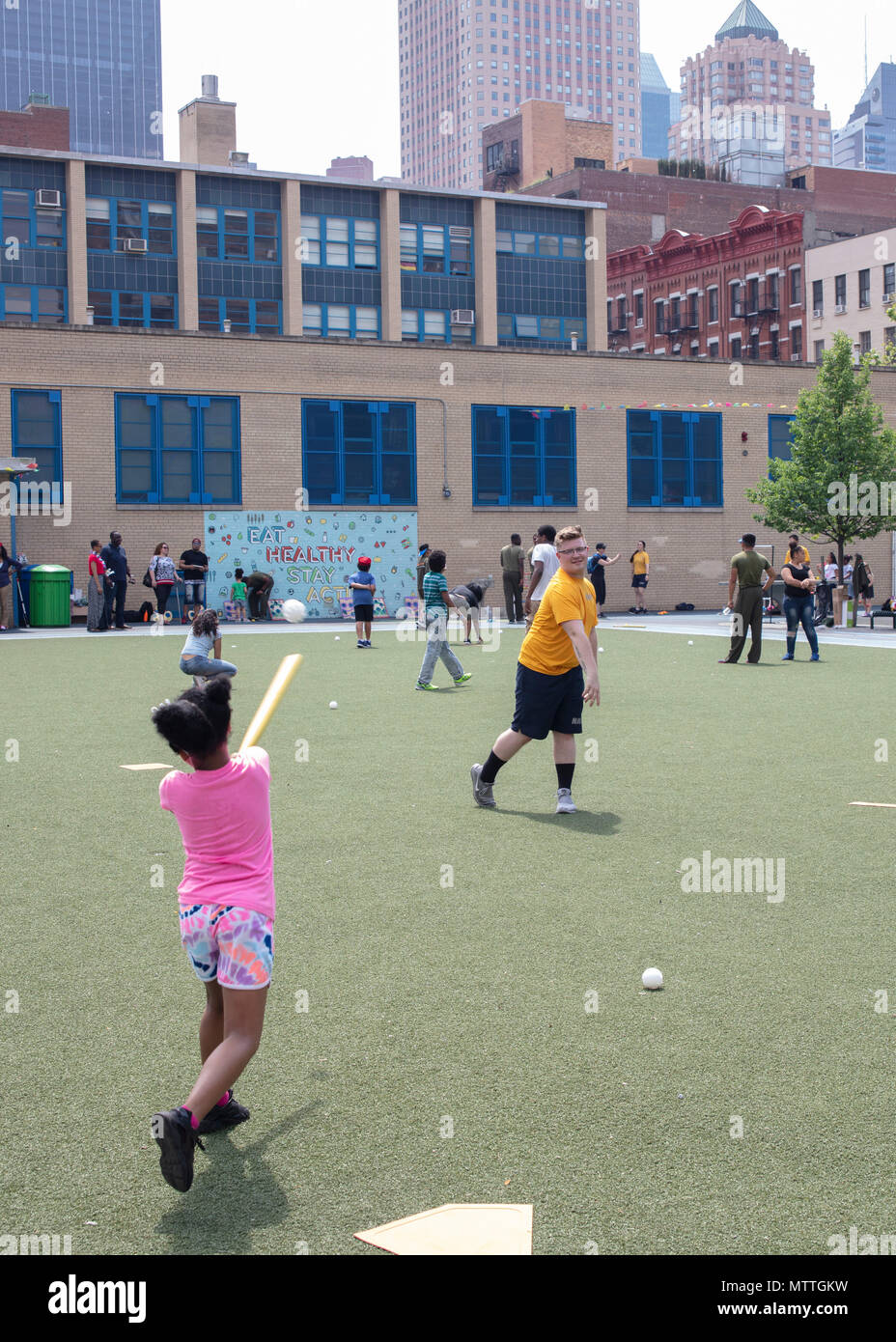 180526-N-HG389-024 NEW YORK (26 mai 2018) pompier Lloyd Minium emplacements une balle wiffle pour un enfant de la région pour "project hope" au cours de la Fleet Week New York (FWNY) 2018, 26 mai. FWNY est le lieu de célébration traditionnelle de la mer services. C'est une occasion unique pour les citoyens de New York et la région des trois états pour répondre marins, marines et gardes côte, ainsi que de constater par moi-même les dernières capacités des services maritimes d'aujourd'hui. (U.S. Photo par marine Spécialiste de la communication de masse 2e classe Brandon Parker/libérés) Banque D'Images