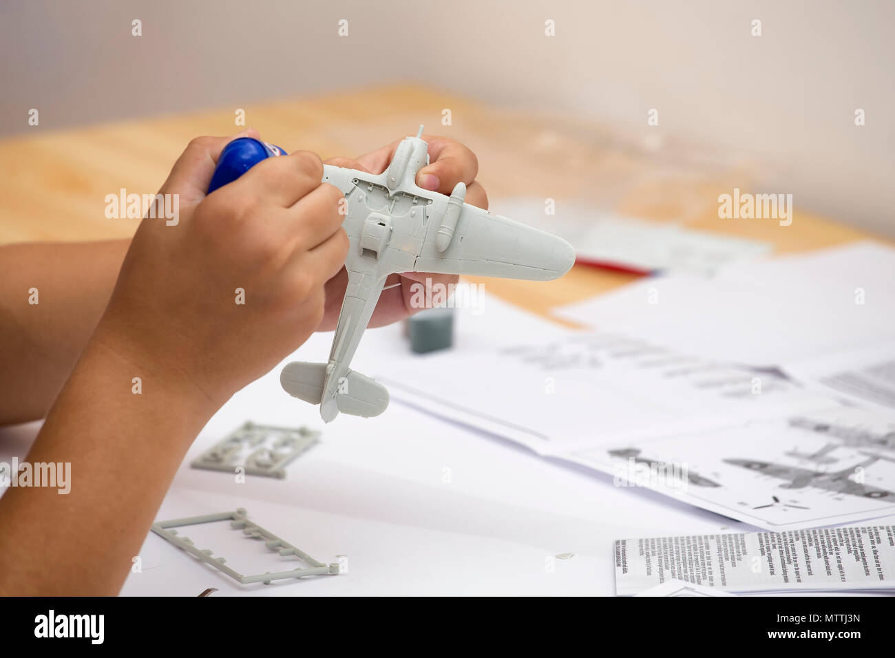 Collage garçon plastic model of ww2 plan d'avions à la maison. Passe-temps et loisirs. Banque D'Images