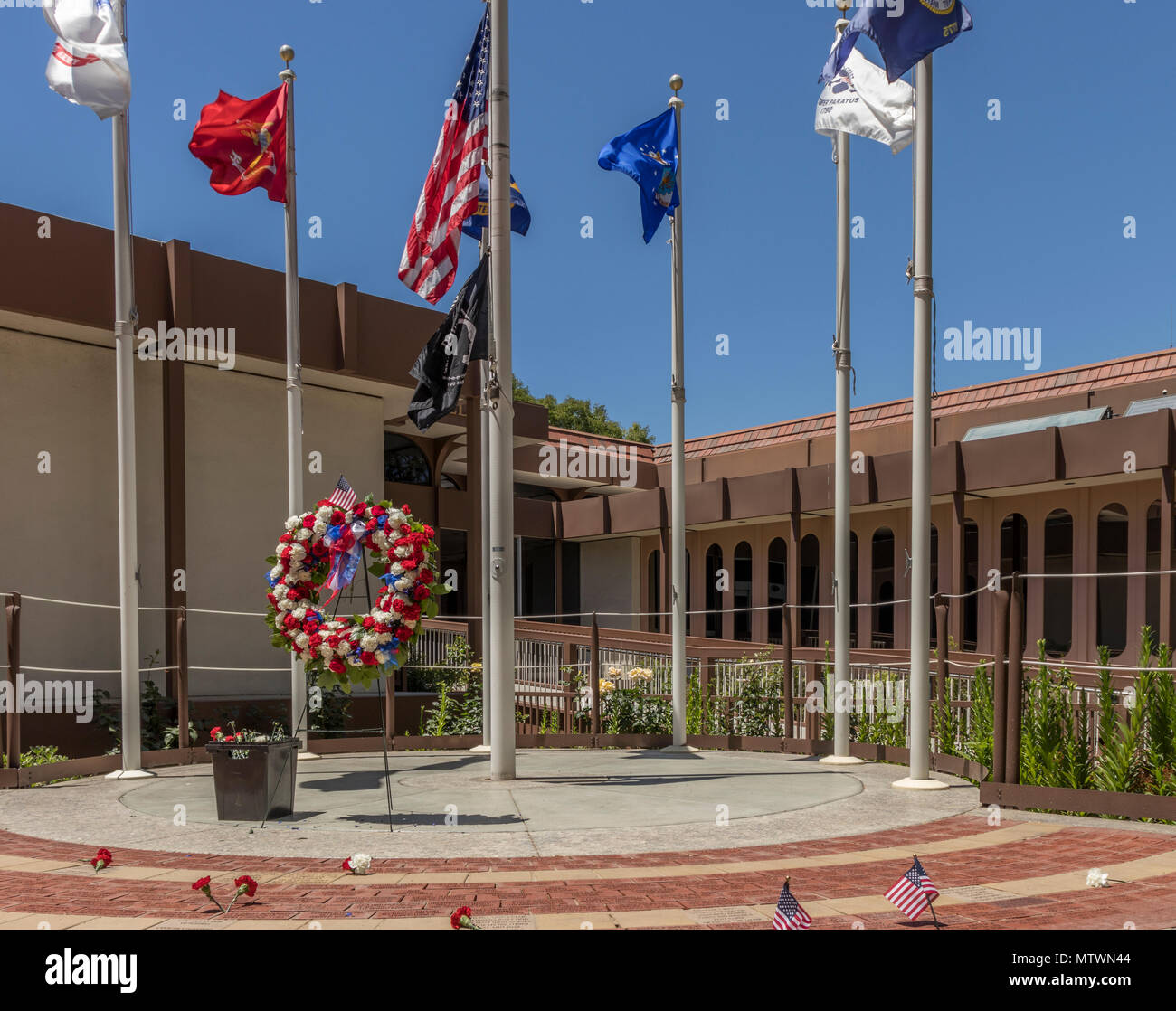 Memorial Day fleurs et drapeaux en souvenir des anciens combattants tombés. Pavé de briques au Memorial Veterans Memorial Plaza, Campbell, Californie, USA. Banque D'Images