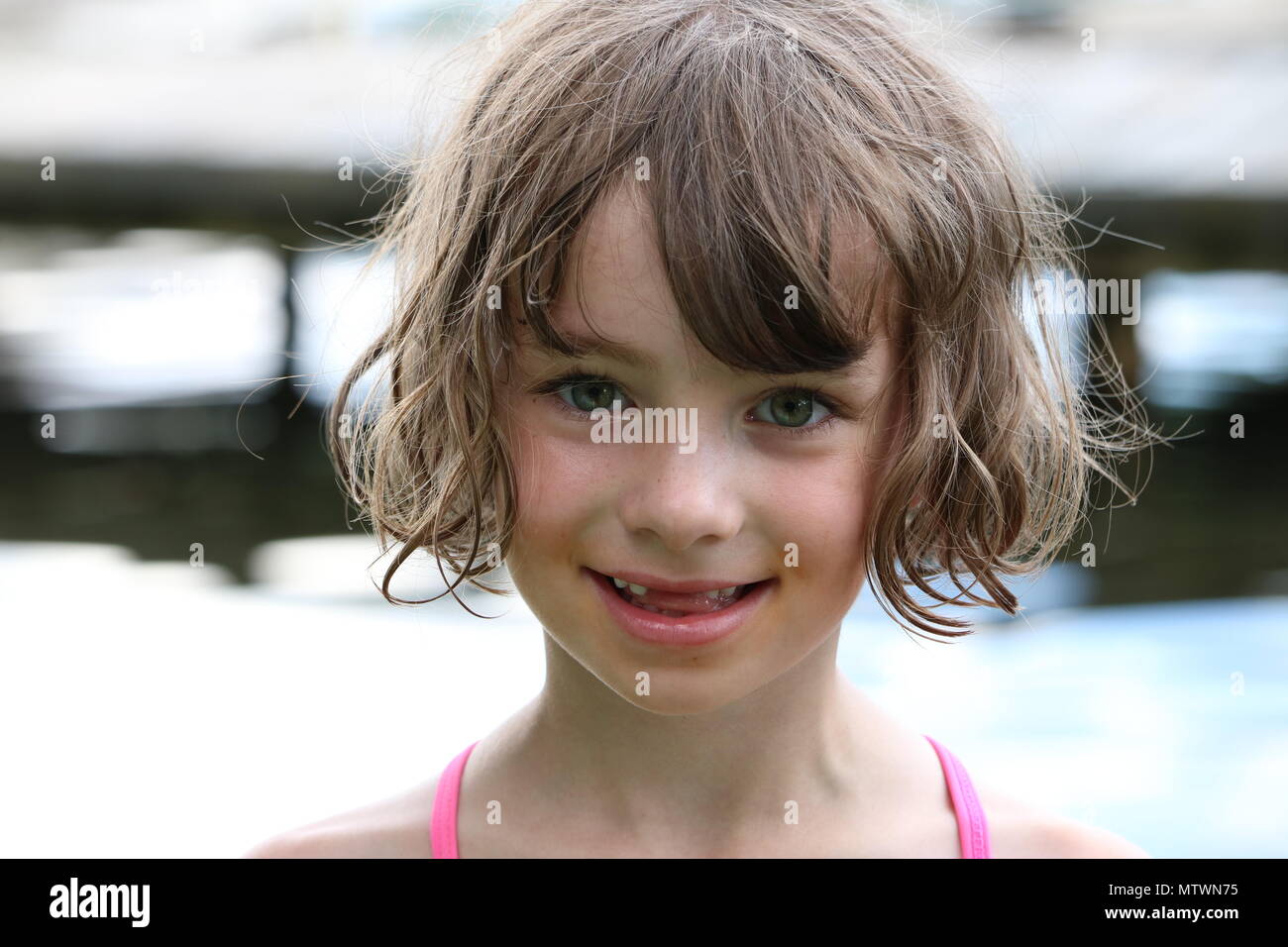 Portrait d'une jeune fille avec des dents avant manquant par un lac Banque D'Images