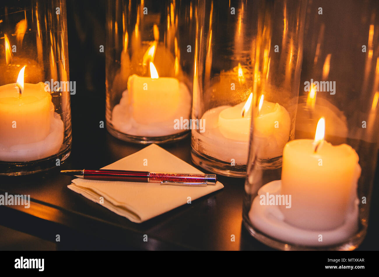 Choix du stylo sur la serviette sur la table par le laminé noir des bougies. Banque D'Images