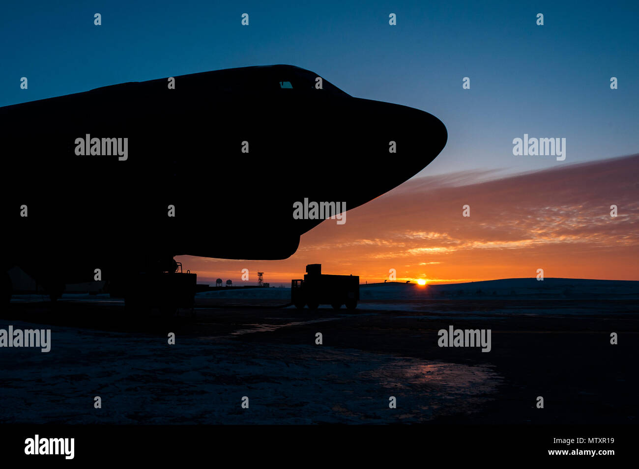 Le soleil se lève derrière un B-52H Stratofortress à Minot Air Force Base, N.D., le 26 janvier 2017. Aviateurs de la 5e Escadron de maintenance de travailler 24 heures dans toutes les conditions météorologiques pour fournir la puissance de feu de B-52 à la demande. (U.S. Air Force photo/Senior Airman J.T. Armstrong) Banque D'Images