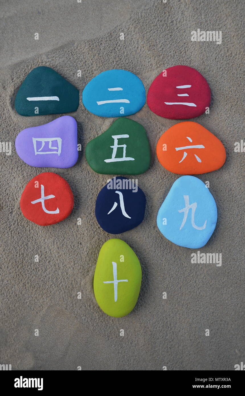 1 à 10, nombres chinois peint sur la mer avec des pierres de couleur de fond de sable Banque D'Images