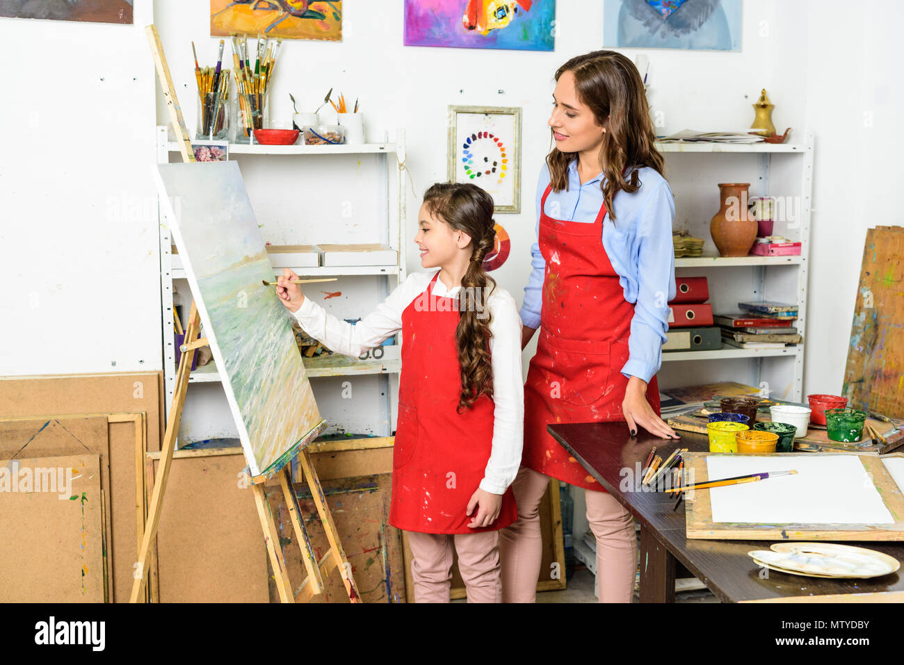 Comment regarder l'enseignant élève peinture sur toile dans l'atelier de l'école d'art Banque D'Images