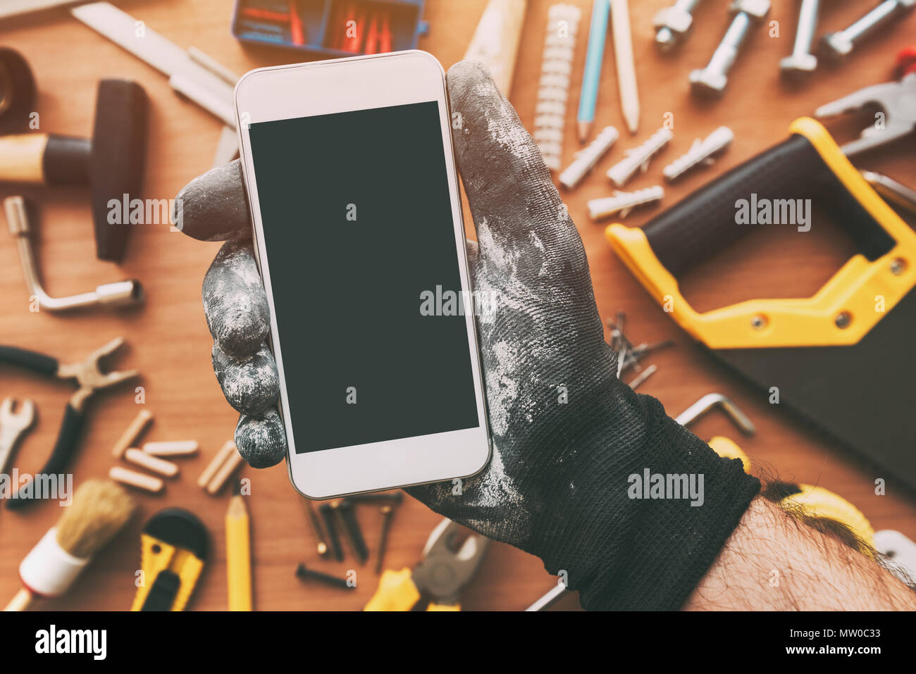 Smart phone app for handyman, réparateur holding mobile phone avec écran vide. Copie de l'espace pour les travaux d'entretien ou de texte Message d'application, vue d'en haut Banque D'Images