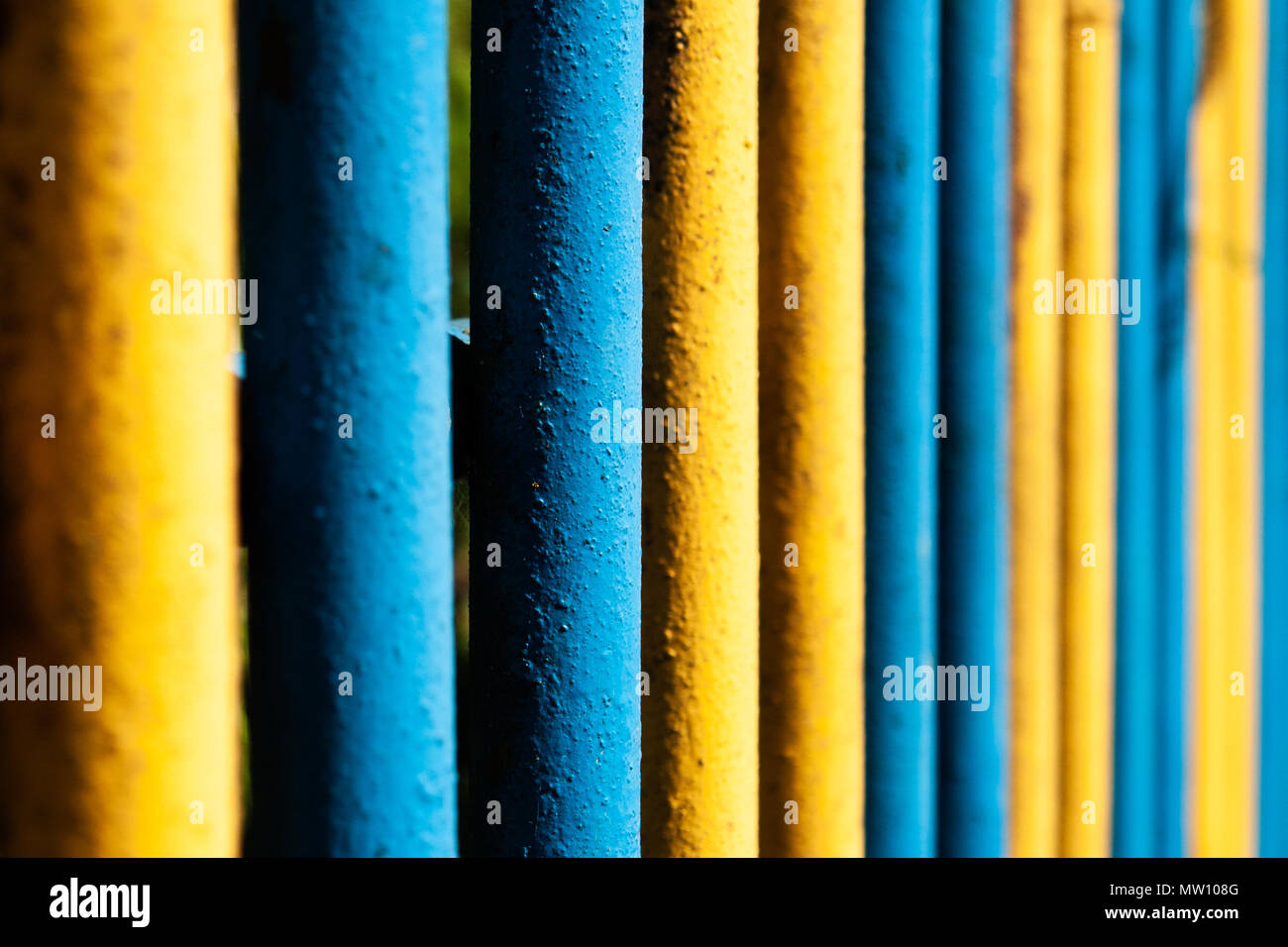 Tuyau jaune et bleu metal fence Banque D'Images