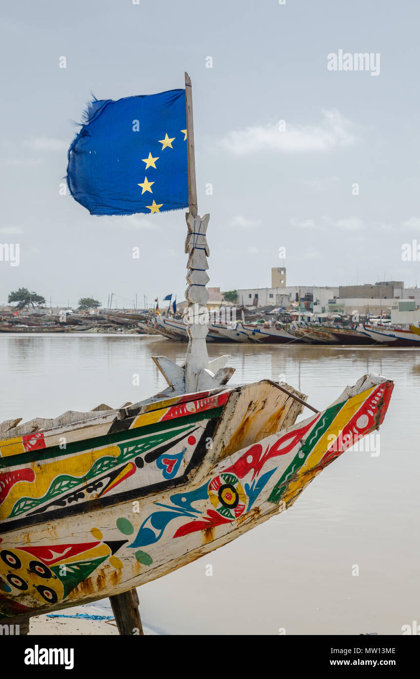 Saint Louis, SÉNÉGAL - 12 octobre 2014 : bateau de pêche en bois peintes aux couleurs vives ou pirogue avec drapeau de l'Union européenne à l'autre. Banque D'Images