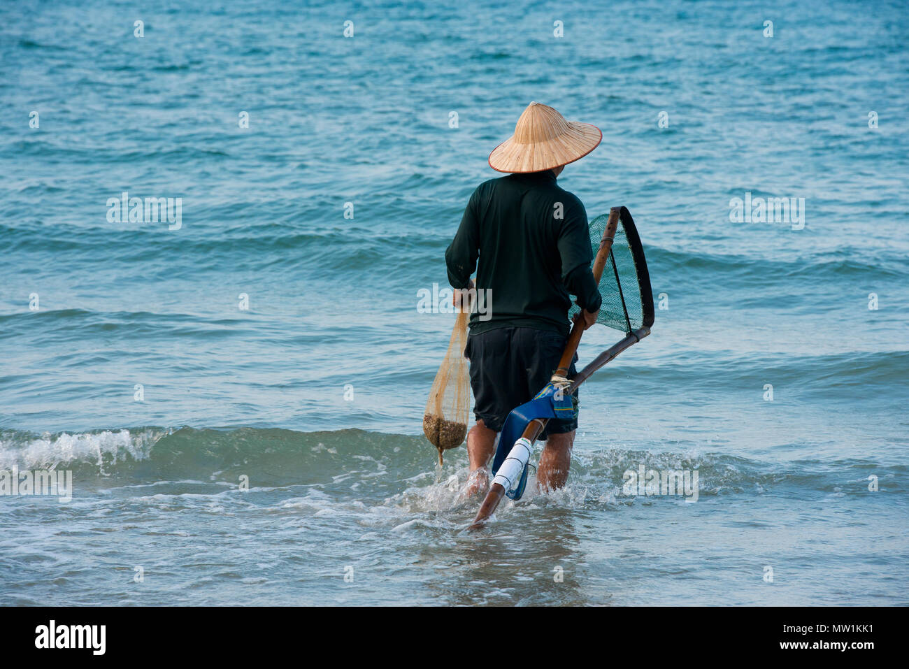 Pêcheur portant un chapeau de paille, la plage Cua Dai à Hoi An, Vietnam Banque D'Images